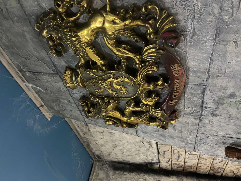 Blason doré du Château Noir dans le décor médiéval de l’escape game près d’Annecy